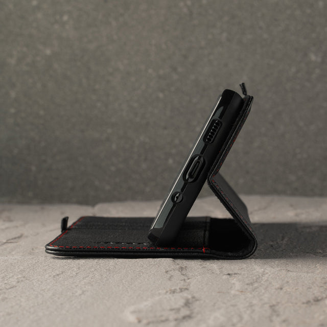 Demonstrating the integrated stand function of the Black Leather (with Red Stitching) Stand Case for Galaxy S20 FE 5G